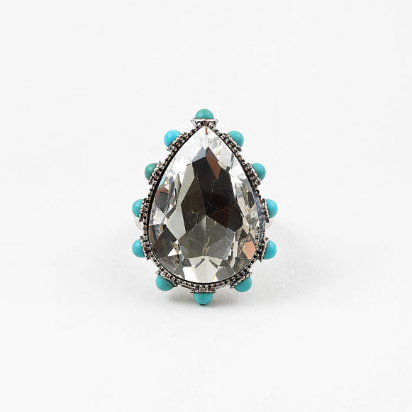 Teardrop-shaped crystal ring with turquoise beads on a white background