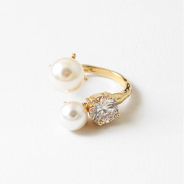 Gold ring with pearls and a diamond on a white background