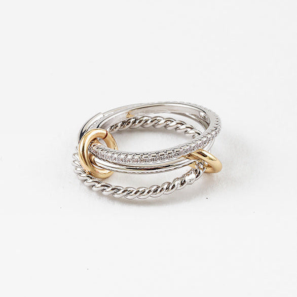 Three stacked rings in gold, silver, and rose gold on a white background