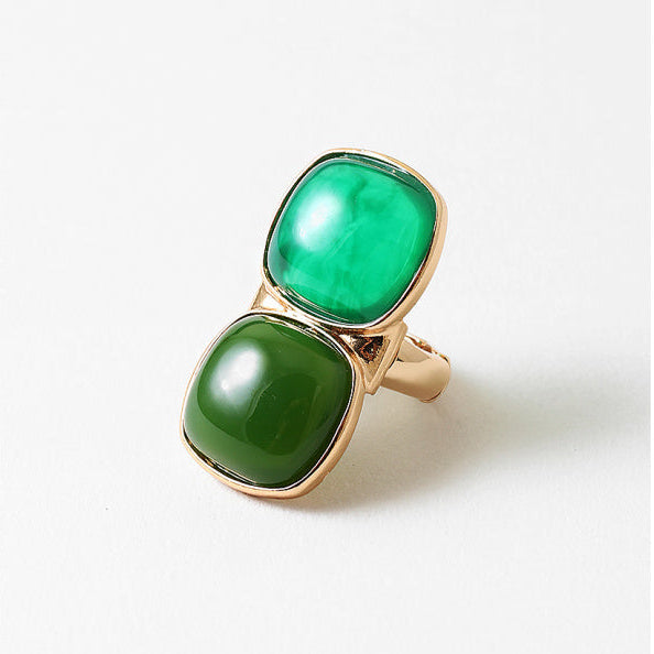 stretch Gold ring with two green gemstones
