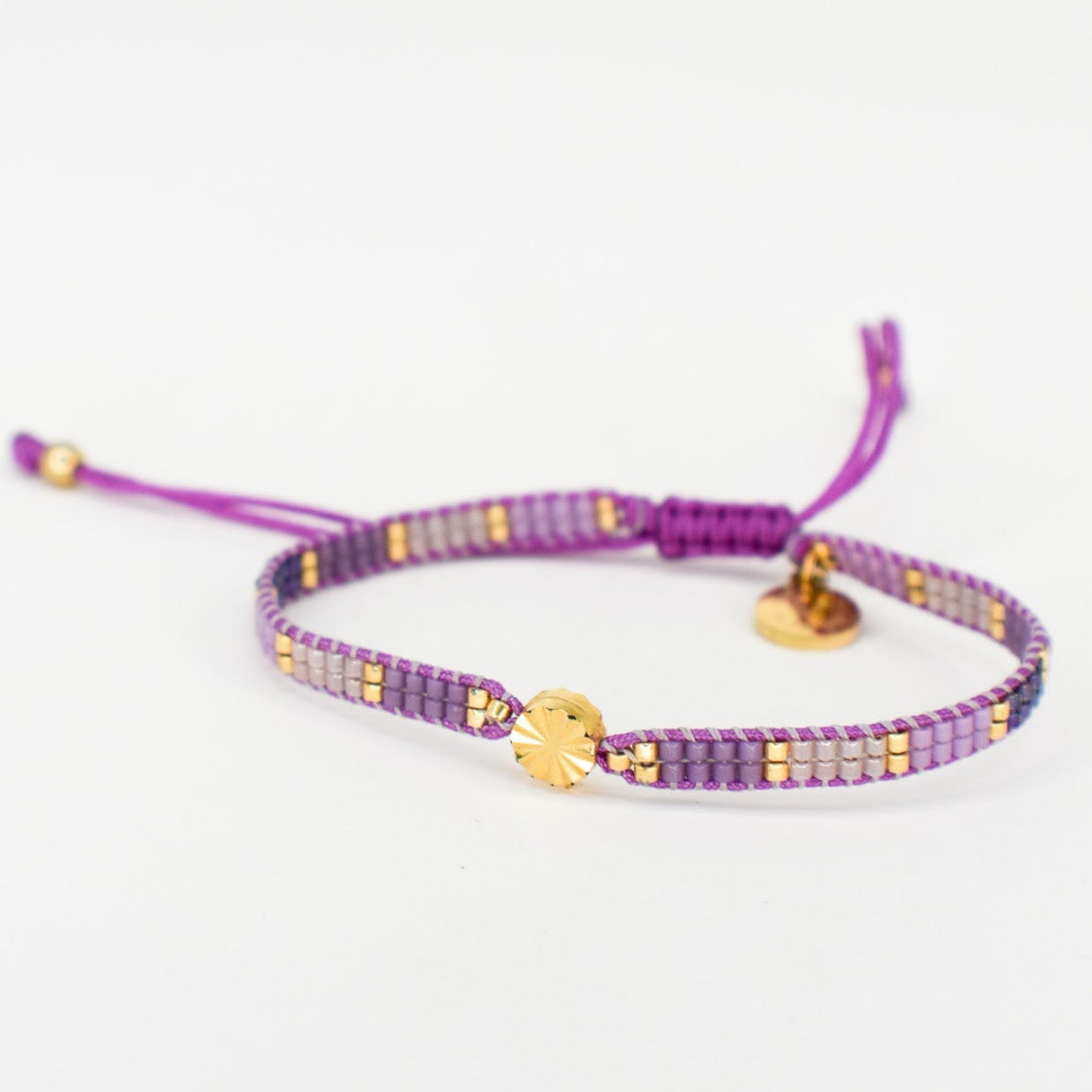 Purple bracelet with gold accents on a white background