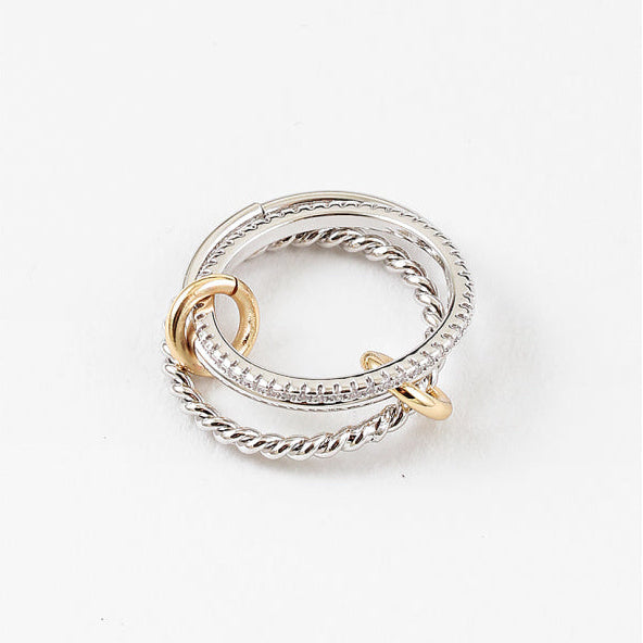 Two interlocking rings, one gold and one silver, on a white background